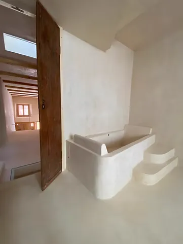 Salle de bains avec baignoire, sol et murs recouverts de Chukum clair.