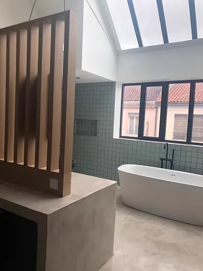 Salle de bains contemporaine avec sol en Chukum, baignoire et verrière.