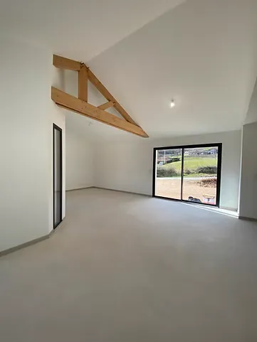 Sol intérieur en Chukum beige dans une pièce lumineuse avec poutre apparente.